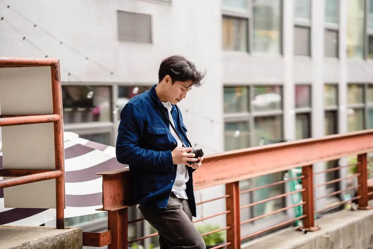 A-Man-in-Blue-Jacket-Holding-a-Camera