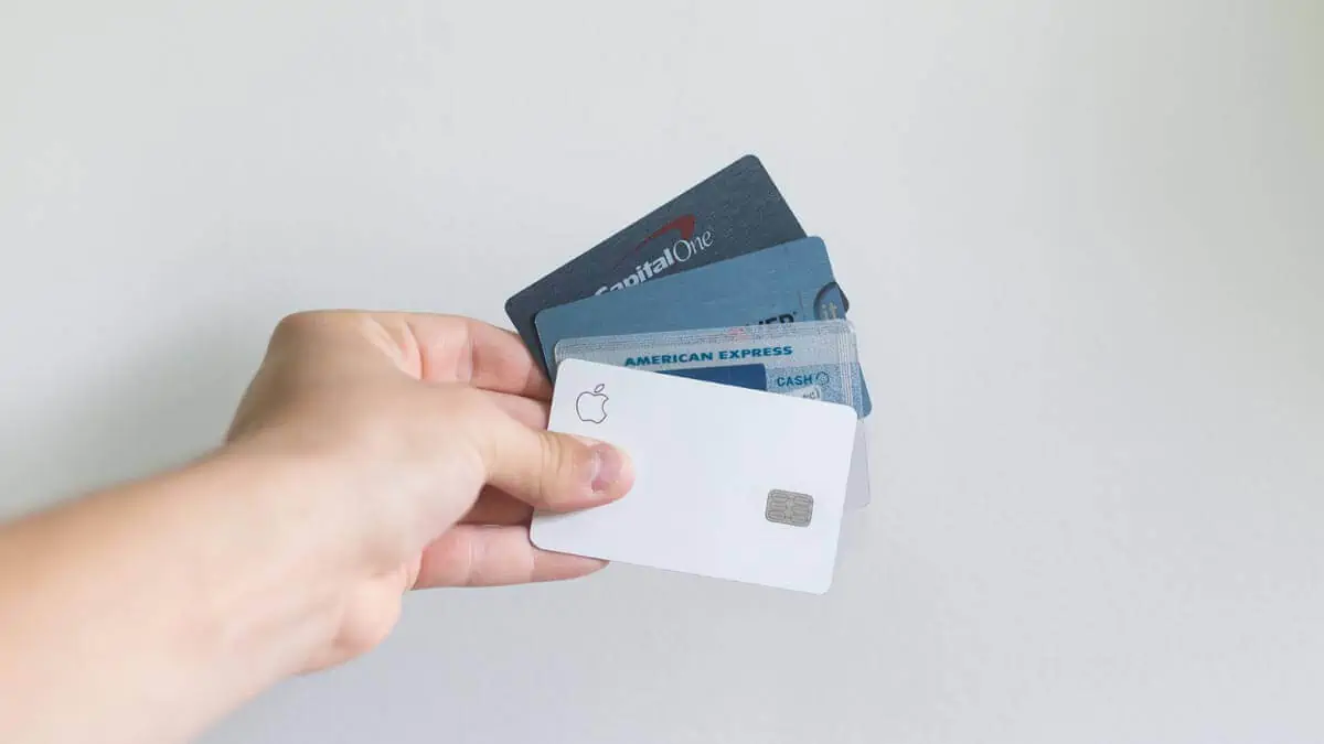 A-person-holding-credit-cards-against-a-white-background-wall