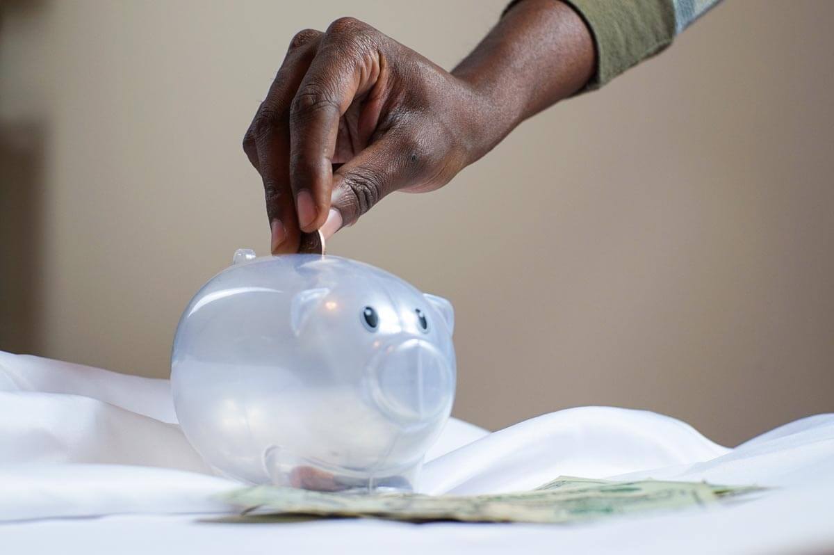 Person-Putting-Coin-in-a-Piggy-Bank