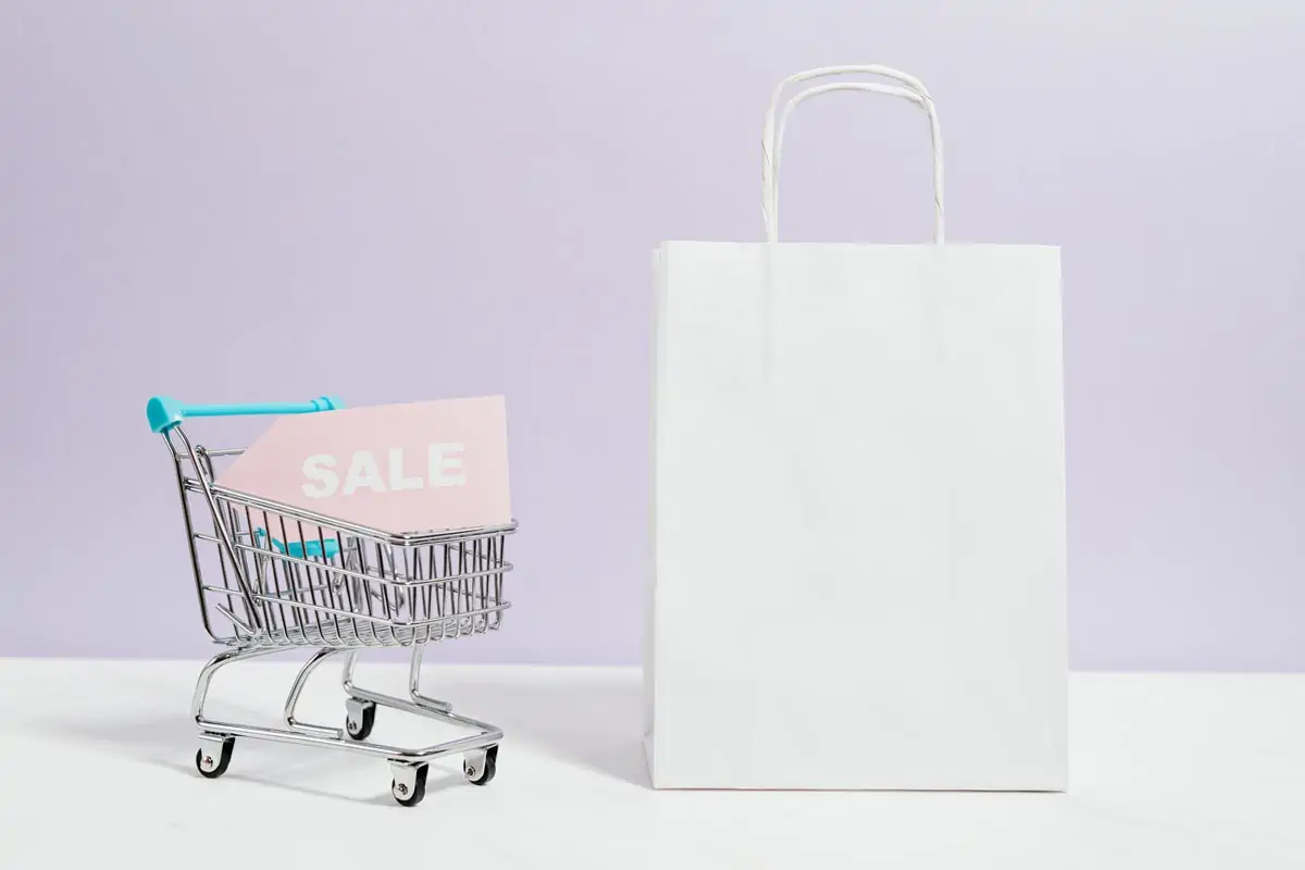 Sale-Sign-In-A-Miniature-Shopping-Cart-And-Paper-Bag