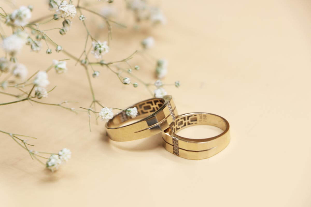 silver-and-gold-wedding-band-on-white-surface